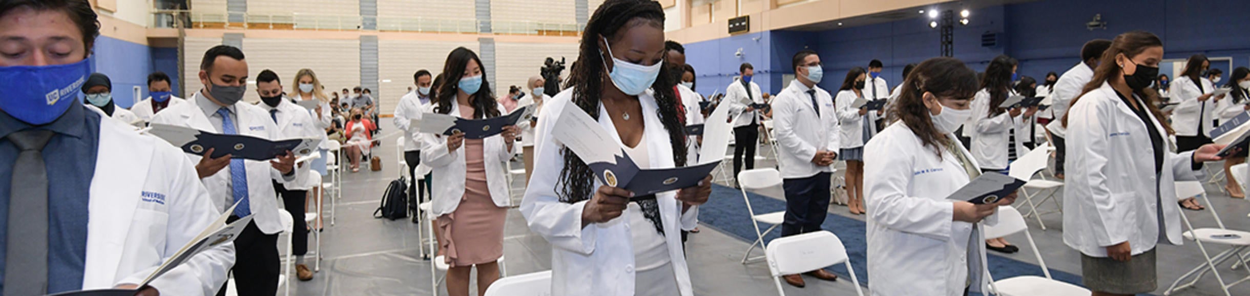 Students reading at white coat ceremony