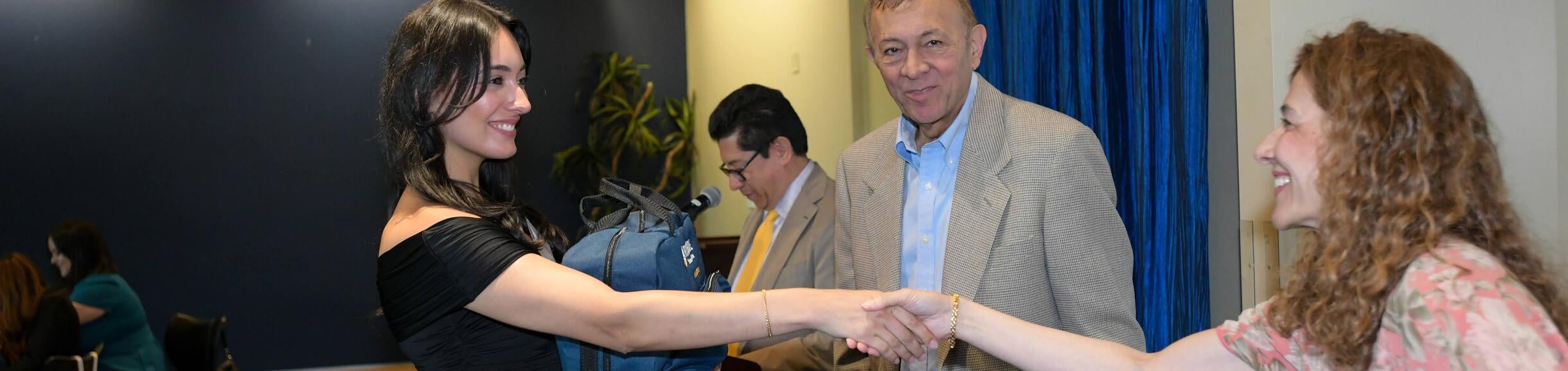 Salma Haider shaking hands as Thomas Haider looks on