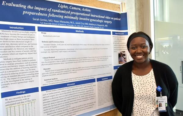 student presenting their poster at dean's research day