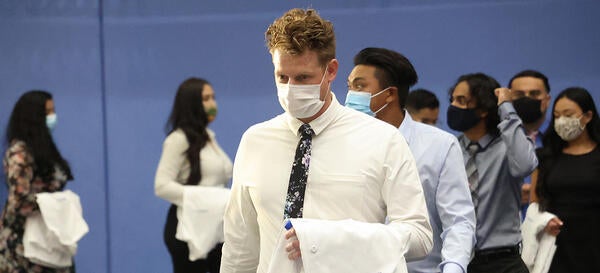 Students walking into white coat ceremony